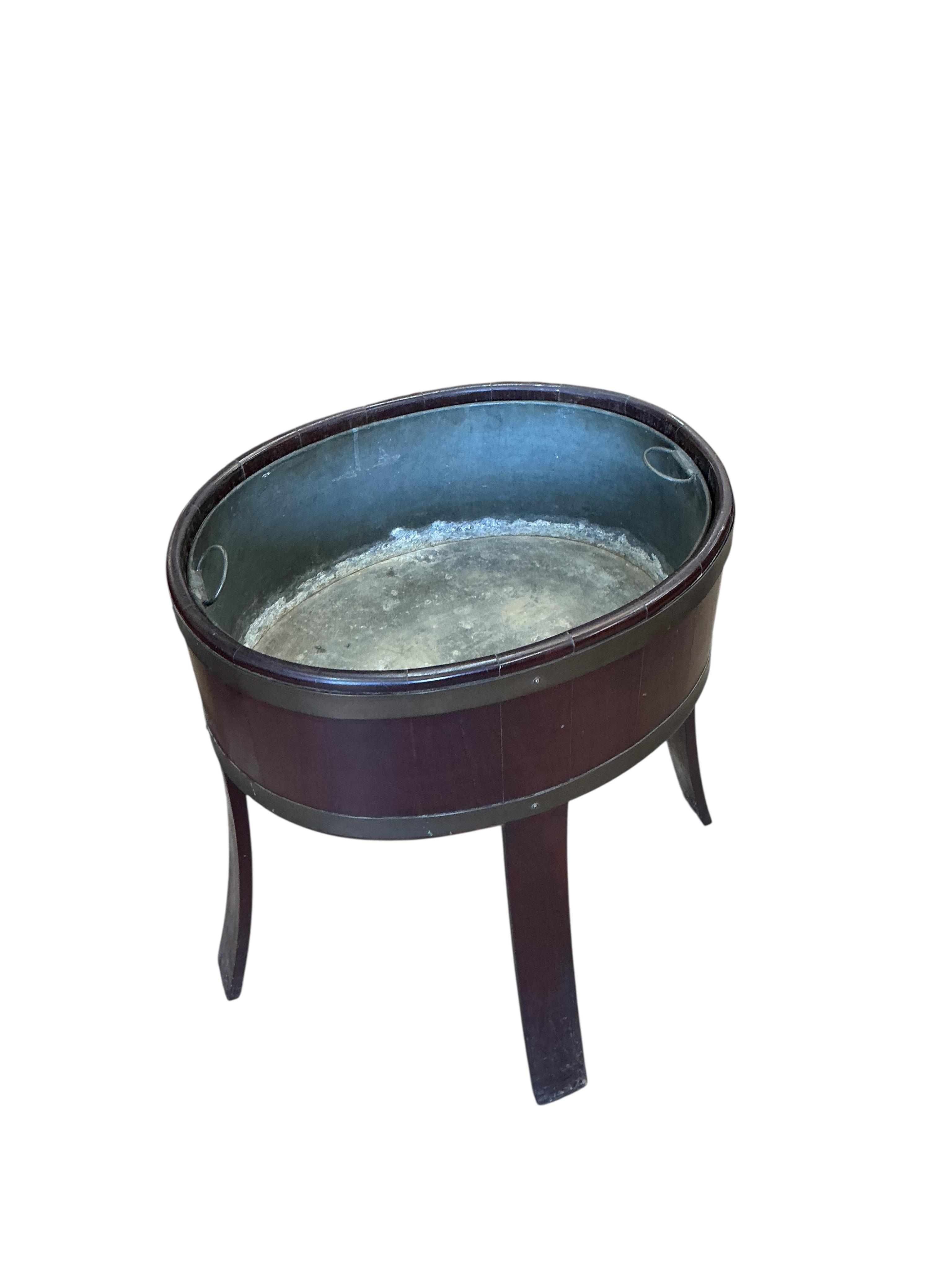 A brass bound oval mahogany jardiniere with liner, width 48cm, depth 34cm, height 62cm